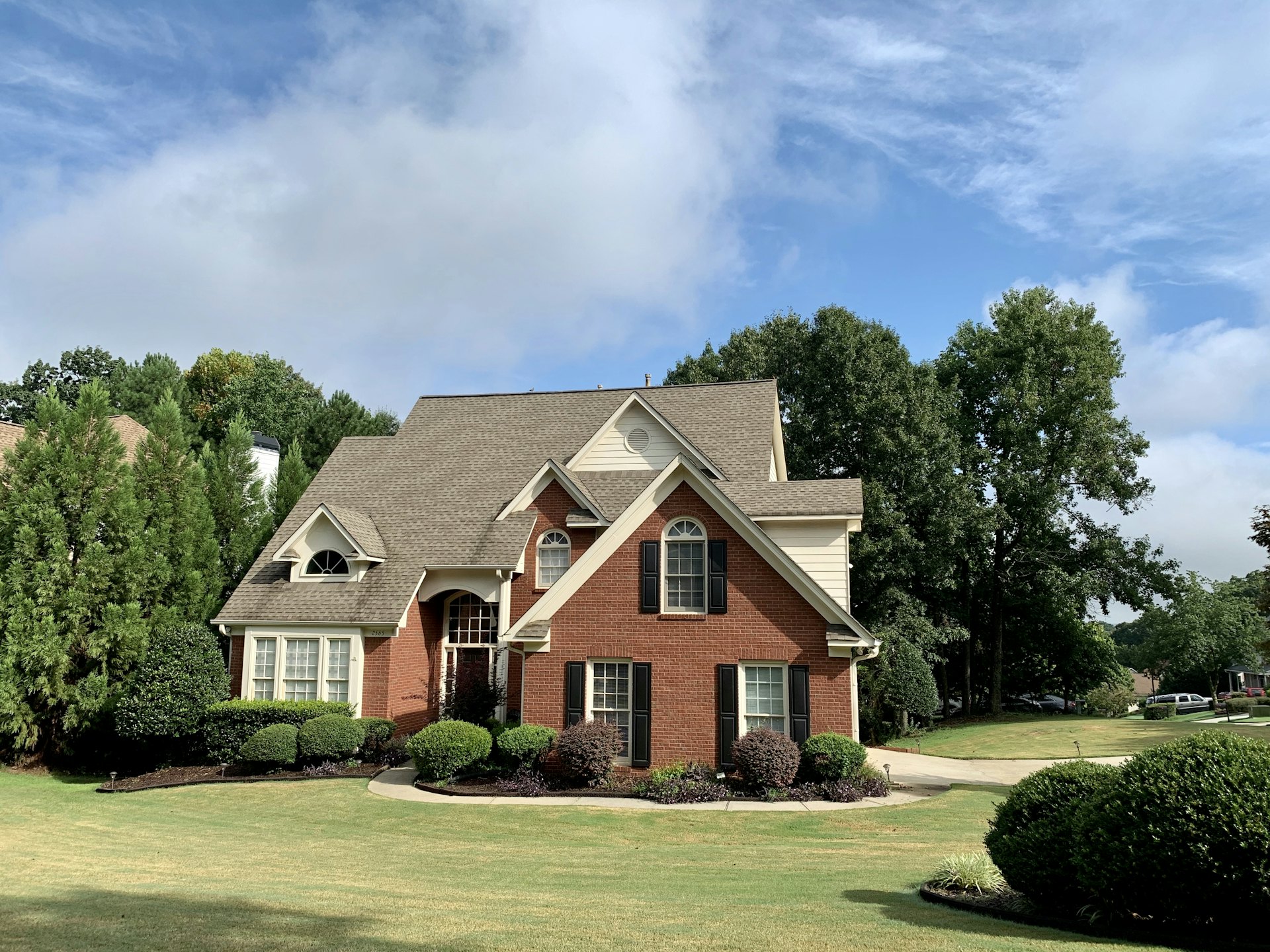 Brick suburban family home with a green lawn