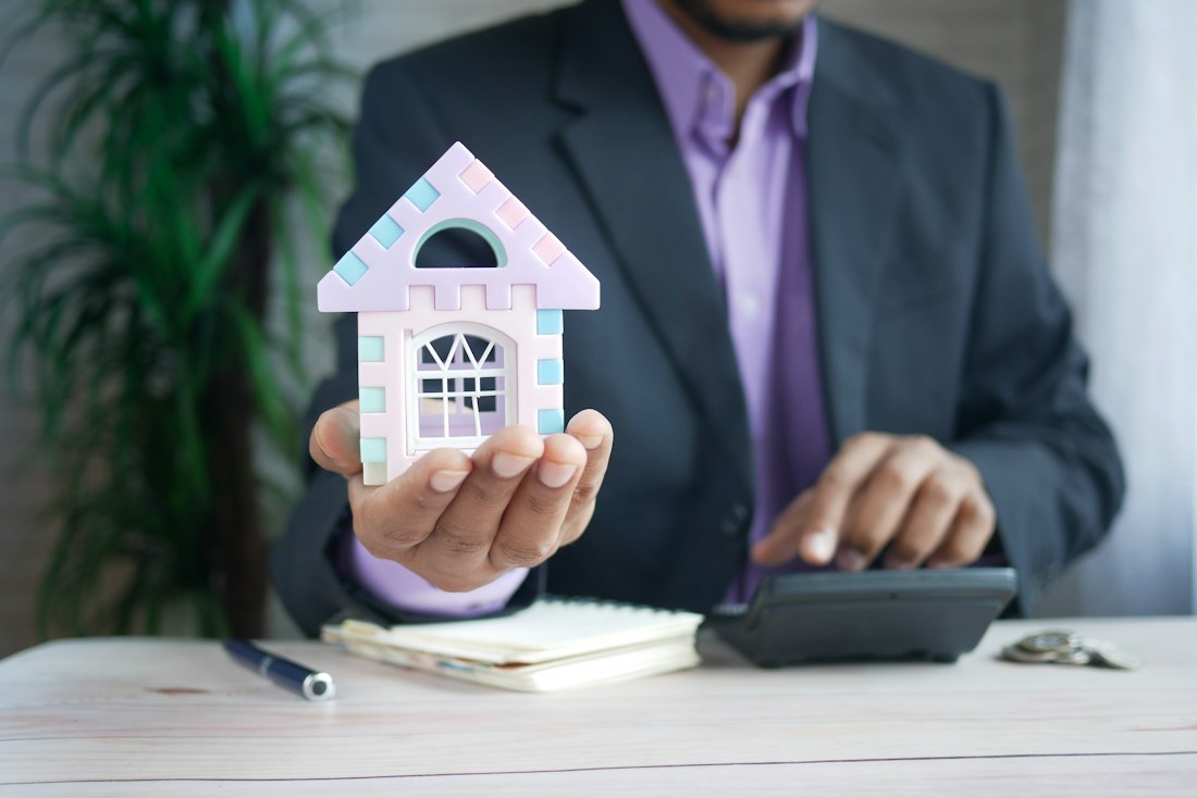 A model house and calculator representing real estate investment analysis